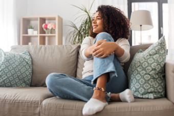 Photo of a woman sitting on a sofa and looking to the left